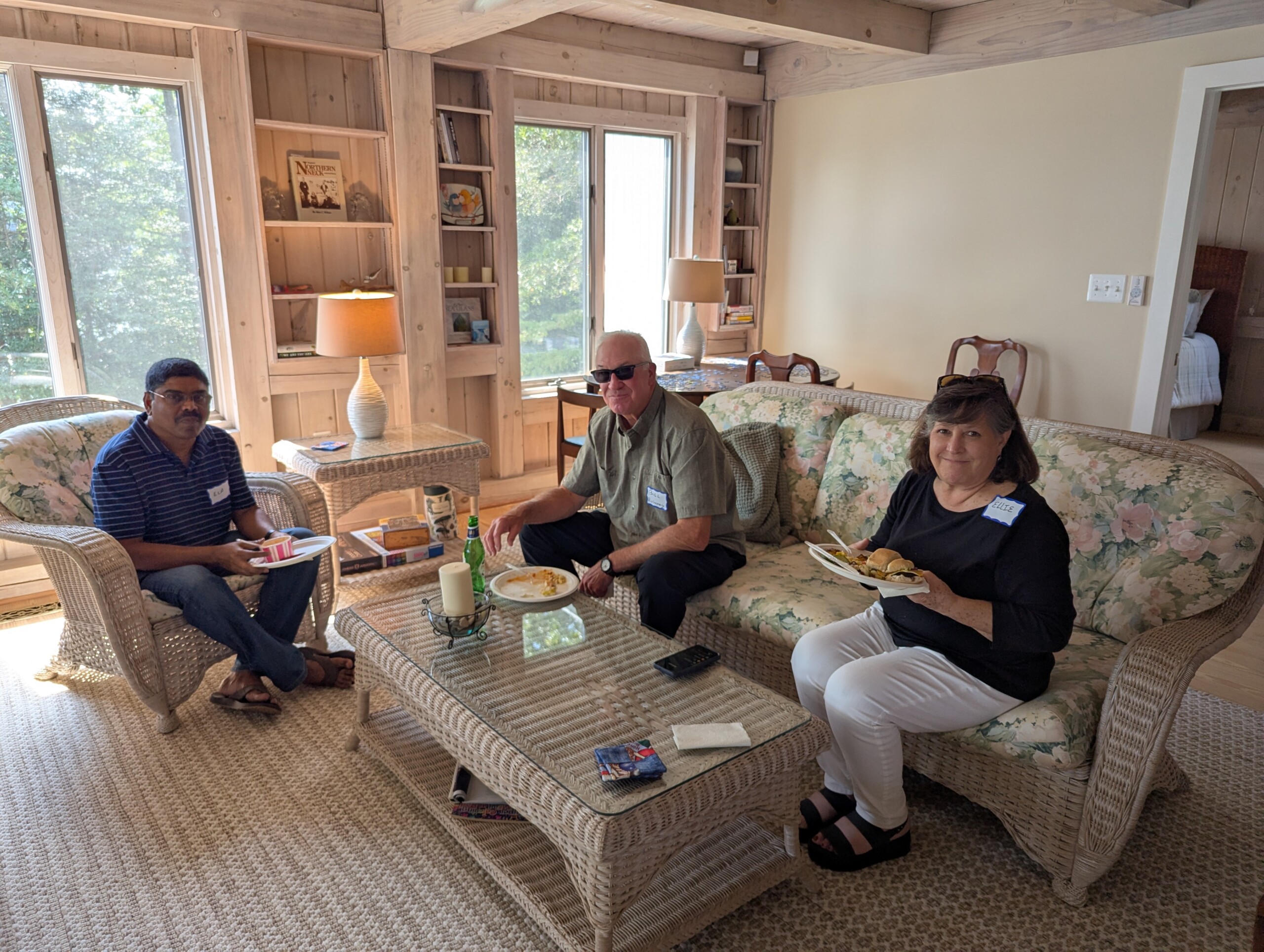 Three people sitting on a couch eating.